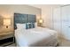 Comfortable bedroom featuring a plush bed with a decorative headboard, soft lighting, and a closet at 812 Driving Range Ct, Reunion, FL 34747