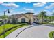 Community clubhouse at Reunion Resort with manicured landscaping and a circular driveway at 812 Driving Range Ct, Reunion, FL 34747