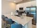 Modern kitchen featuring white cabinets, stainless steel appliances, and an island with barstool seating at 812 Driving Range Ct, Reunion, FL 34747