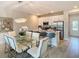 Modern kitchen featuring stainless steel appliances, an island with seating, and an adjacent dining area at 812 Driving Range Ct, Reunion, FL 34747
