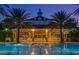 A stunning pool and pavilion area with decorative lighting and well manicured palm trees at 812 Driving Range Ct, Reunion, FL 34747