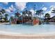 Outdoor view of a water park play structure for children, filled with water, and surrounded by palm trees at 812 Driving Range Ct, Reunion, FL 34747
