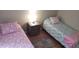 Bright bedroom featuring two beds with colorful unicorn and mermaid themed bedding and a wooden nightstand at 8447 Crystal Cove Loop # 8447, Kissimmee, FL 34747