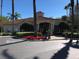 Exterior view of the clubhouse with red flowers and palm trees at 8447 Crystal Cove Loop # 8447, Kissimmee, FL 34747