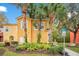 Charming yellow home with well-kept landscaping and mature palm trees enhancing curb appeal at 8447 Crystal Cove Loop # 8447, Kissimmee, FL 34747