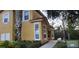 Exterior view of a light-yellow townhouse showing a side entrance and adjacent landscaping at 8447 Crystal Cove Loop # 8447, Kissimmee, FL 34747
