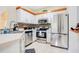 This kitchen is bright with white cabinets, stainless steel appliances, and a mosaic tile backsplash at 8447 Crystal Cove Loop # 8447, Kissimmee, FL 34747