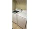 Modern laundry room featuring a side-by-side washer and dryer, with overhead storage at 8447 Crystal Cove Loop # 8447, Kissimmee, FL 34747
