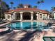 Community pool with lounge chairs, tables, and manicured landscaping at 8447 Crystal Cove Loop # 8447, Kissimmee, FL 34747