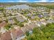 Aerial view showcases community homes, lush greenery, and proximity to a large scenic lake at 8676 Currituck Sound Ln, Orlando, FL 32829