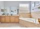 The bathroom features a large soaking tub, vanity with cabinet storage, and a tiled wall at 8676 Currituck Sound Ln, Orlando, FL 32829