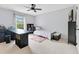 Well-lit bedroom with a twin bed, black desk, neutral walls, and carpeted floor at 8676 Currituck Sound Ln, Orlando, FL 32829