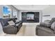 Living room features hardwood floors, TV, and large windows with natural light at 8676 Currituck Sound Ln, Orlando, FL 32829