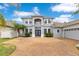 Stunning two-story home featuring a brick driveway, lush landscaping, and a welcoming double-door entrance at 8676 Currituck Sound Ln, Orlando, FL 32829