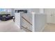 Bright hallway featuring staircase with carpeted floor and living room with dark furniture in background at 8676 Currituck Sound Ln, Orlando, FL 32829