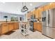 This well-lit kitchen features stainless steel appliances, tiled floors, light wood cabinets and a movable island at 8676 Currituck Sound Ln, Orlando, FL 32829