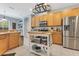 Well-lit kitchen features stainless steel appliances, tiled floors, light wood cabinets and a movable island at 8676 Currituck Sound Ln, Orlando, FL 32829