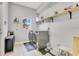 Bright laundry room with washer, dryer, shelving, and window at 8676 Currituck Sound Ln, Orlando, FL 32829