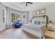 This main bedroom features hard wood floors, a ceiling fan and a large window with a seating area at 8676 Currituck Sound Ln, Orlando, FL 32829
