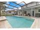 Spacious in-ground pool under a screened enclosure featuring outdoor furniture on the patio at 8676 Currituck Sound Ln, Orlando, FL 32829