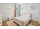 Bright bedroom with a window, wood flooring, a rug, and a pink upholstered bed at 9843 Nokay Dr, Orlando, FL 32836