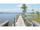 Lakefront property featuring a private dock with wooden planks, sturdy railings, and scenic water views on a sunny day at 9843 Nokay Dr, Orlando, FL 32836