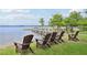 Relaxing lakefront seating with Adirondack chairs offers a serene outdoor experience by the water at 9843 Nokay Dr, Orlando, FL 32836