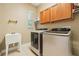 Well-lit laundry room featuring a utility sink, side-by-side washer and dryer, and overhead cabinets at 9843 Nokay Dr, Orlando, FL 32836
