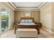 Comfortable main bedroom featuring tray ceiling, wood accents, bench, and neutral colors at 9843 Nokay Dr, Orlando, FL 32836