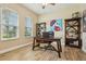 Bright office with wood-look tile flooring, two large windows, and custom built-in bookshelves at 9843 Nokay Dr, Orlando, FL 32836