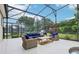 Screened patio featuring comfortable wicker seating, a wooden coffee table, and a stainless steel grill for outdoor entertaining at 9843 Nokay Dr, Orlando, FL 32836