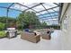 Relaxing screened patio with a grill, wicker furniture, and a view of the inviting swimming pool, perfect for outdoor lounging at 9843 Nokay Dr, Orlando, FL 32836