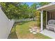 Well-maintained backyard with a white fence, green grass, and a comfortable seating area at 10124 Pink Carnation Ct, Orlando, FL 32825