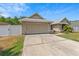 Well-kept home with a spacious driveway, attached garage, and manicured landscaping at 10124 Pink Carnation Ct, Orlando, FL 32825