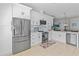 Bright kitchen with white cabinets, stainless steel appliances, and a breakfast bar overlooking the dining area at 10124 Pink Carnation Ct, Orlando, FL 32825