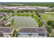 Aerial view showcases the community pond, lush landscaping, pool, and townhome exteriors at 1027 Cedar Bay Ln, Winter Springs, FL 32708