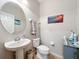 Cozy half-bathroom with a pedestal sink, round mirror and tile flooring at 1027 Cedar Bay Ln, Winter Springs, FL 32708