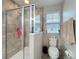Bathroom featuring a tiled glass door shower and toilet with window at 1027 Cedar Bay Ln, Winter Springs, FL 32708