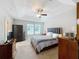 Cozy bedroom features a tray ceiling with ceiling fan, carpet floors, and an accent wall at 1027 Cedar Bay Ln, Winter Springs, FL 32708