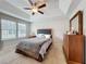 Inviting bedroom features carpet flooring, tray ceiling, windows, and wooden dresser at 1027 Cedar Bay Ln, Winter Springs, FL 32708