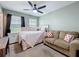 Bright bedroom with ceiling fan, queen bed, sofa, and view of the outdoors at 1027 Cedar Bay Ln, Winter Springs, FL 32708