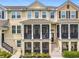 Close up of three-story townhome featuring screened porch, stairs leading to the entry, and well-kept landscaping at 1027 Cedar Bay Ln, Winter Springs, FL 32708