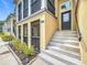 Inviting two-story townhome exterior with black railings, tan stucco, and landscaped front yard at 1027 Cedar Bay Ln, Winter Springs, FL 32708
