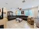 Spacious living room with tile floors, ceiling fan, and a large sectional sofa near bright windows at 1027 Cedar Bay Ln, Winter Springs, FL 32708