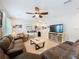 Large living room featuring tile flooring, a brown sectional sofa and a TV, offering a comfortable space at 1027 Cedar Bay Ln, Winter Springs, FL 32708