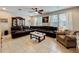 Bright living room with tile floors, a ceiling fan, and a comfortable sectional sofa near sunlit windows at 1027 Cedar Bay Ln, Winter Springs, FL 32708