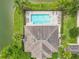 Aerial view of a community pool and clubhouse surrounded by a serene lake and lush greenery at 1027 Cedar Bay Ln, Winter Springs, FL 32708