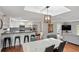 Bright dining area features modern light fixture, seating for six, brick accent wall, and opens to living room at 103 Cherry Hill Cir, Longwood, FL 32779