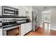Kitchen features stainless steel appliances, a black countertop, white cabinets, and hardwood floors at 103 Cherry Hill Cir, Longwood, FL 32779