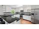 Modern kitchen features white cabinets, black countertops and backsplash, stainless steel appliances, and breakfast bar at 103 Cherry Hill Cir, Longwood, FL 32779